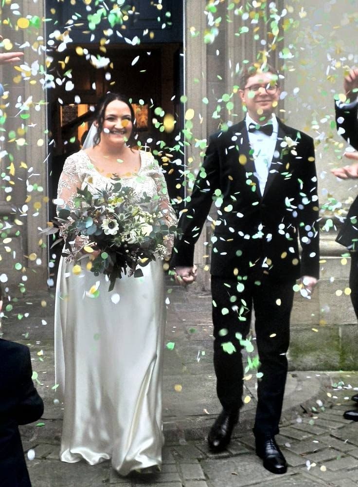 A newly married couple leaving St George's under confetti